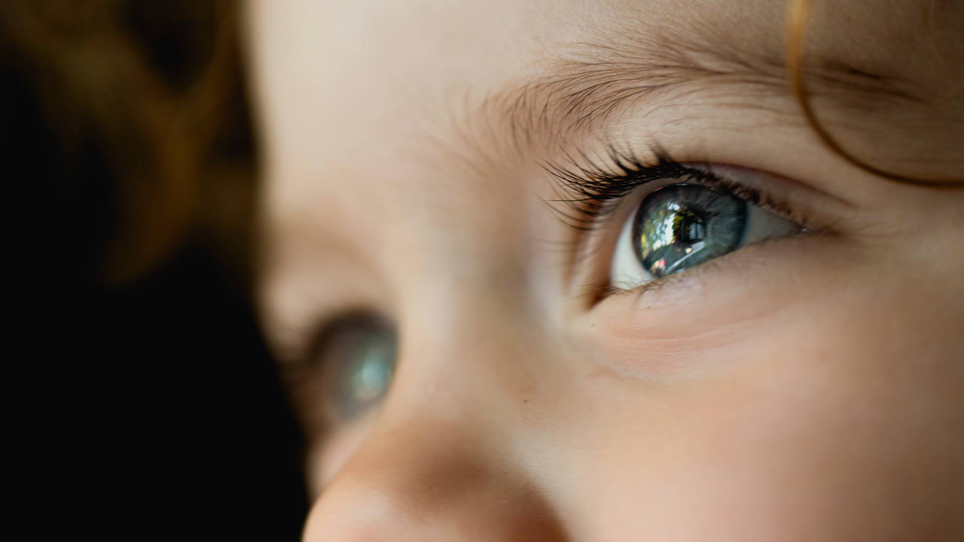 close up of childs eyes as he looks into a light during video production