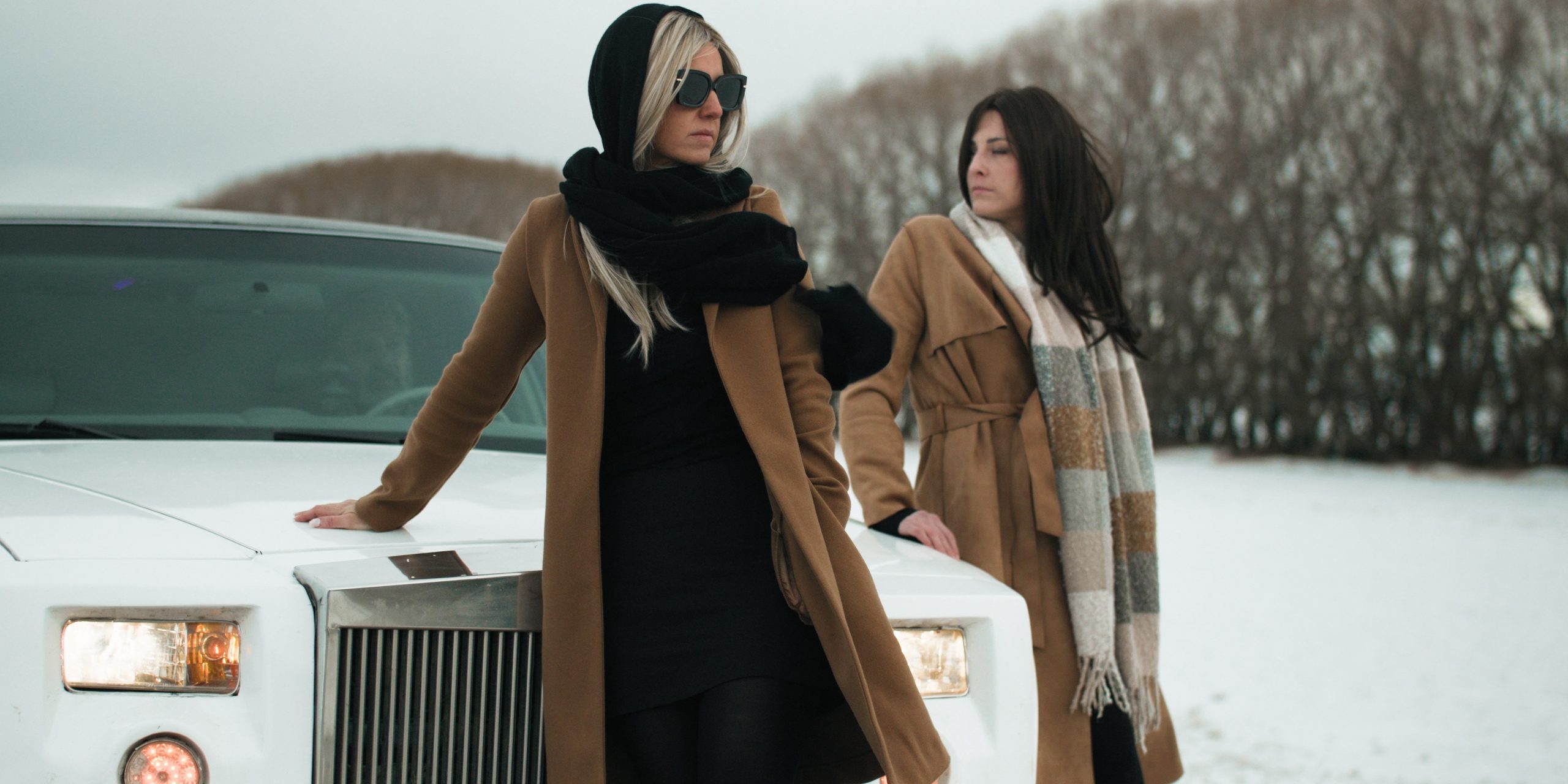 Two women standing by a limo on a cold windy day